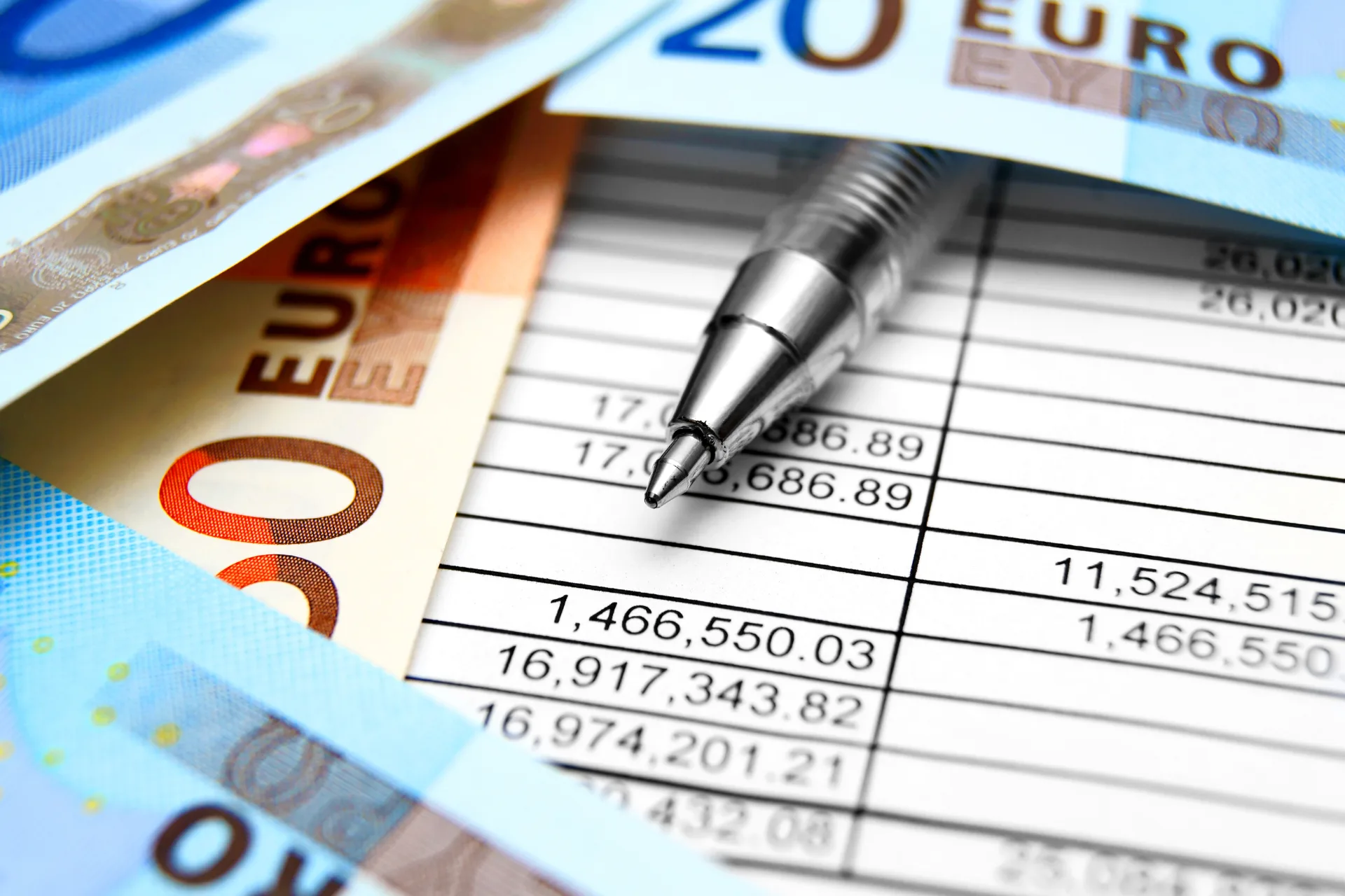 Zilveren pen boven een financieel document met eurotekens